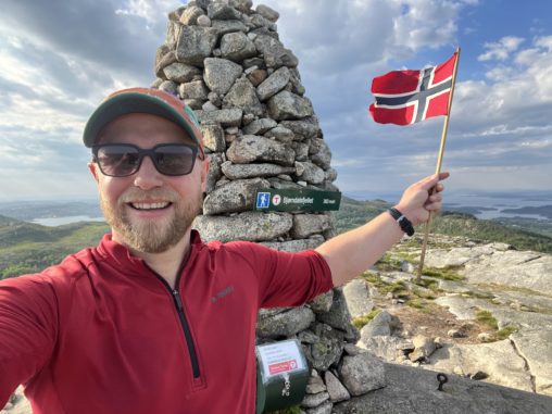 Turguide vifter med flagg på toppen av et fjell